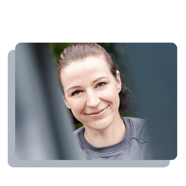 Ein Porträt der Fitnesstrainerin Hanna Winter, die freundlich in dier Kamera lächelt.