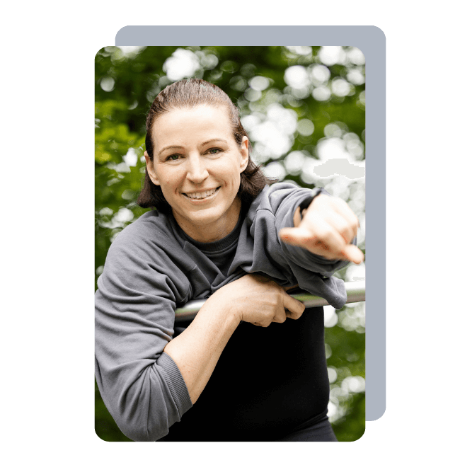 Ein Foto der Fitnesstrainerin Hanna Winter, die lachend ihren linken Arm ausstreckt und mit ihrem Zeigefinger auf den Betrachter zeigt.